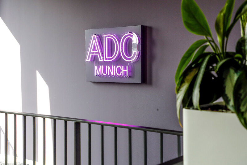 Bild eines Neon-Schildes mit der Aufschrift "ADC Munich"