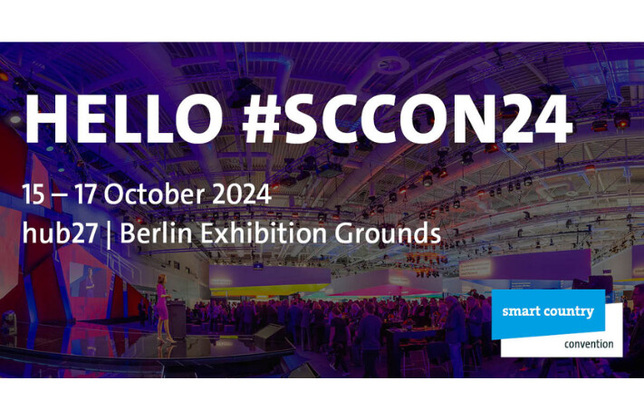 Text auf dem Bild lautet "Hello #Smart Country Convention 24" von 15. - 17. Oktober 2024 in Berlin - Im Hintergrund ist die Messehalle abgebildet